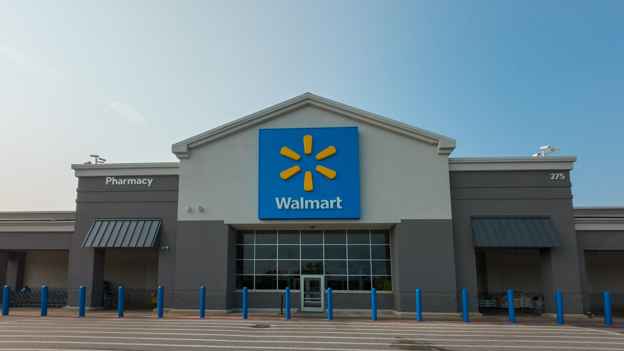 Front view of a Walmart store with its blue and yellow logo on the facade under clear daylight